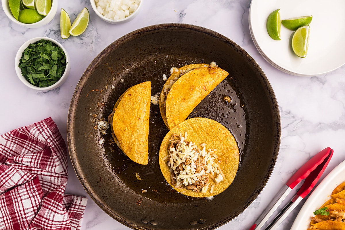 making chicken birria tacos in a skillet