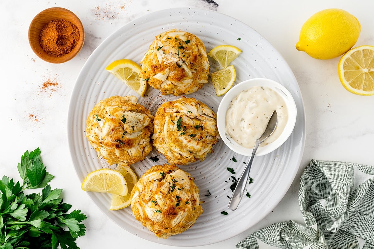 serving platter with crab cake sauce and lemons