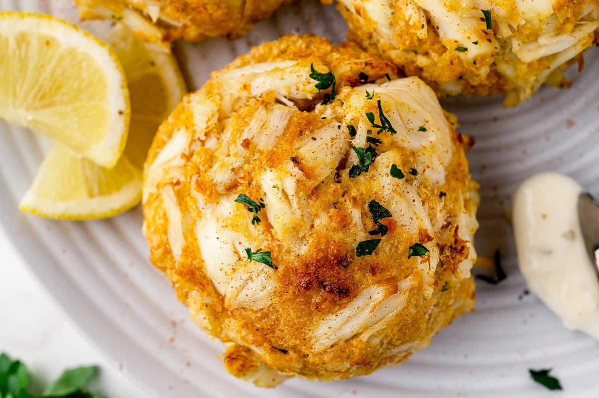 close up of an old bay dusted crab cake with parsley garnish