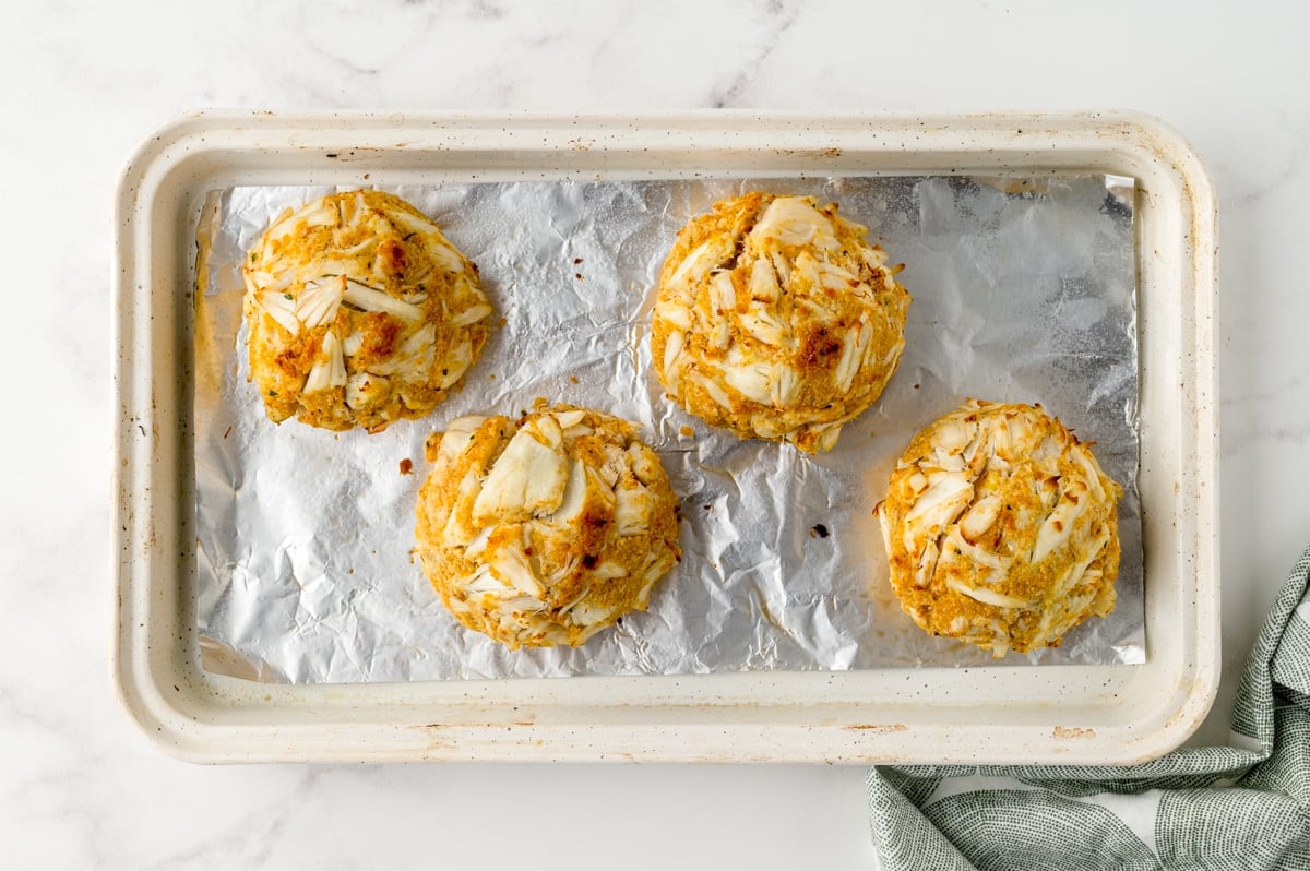 cooked crab cakes on a baking sheet