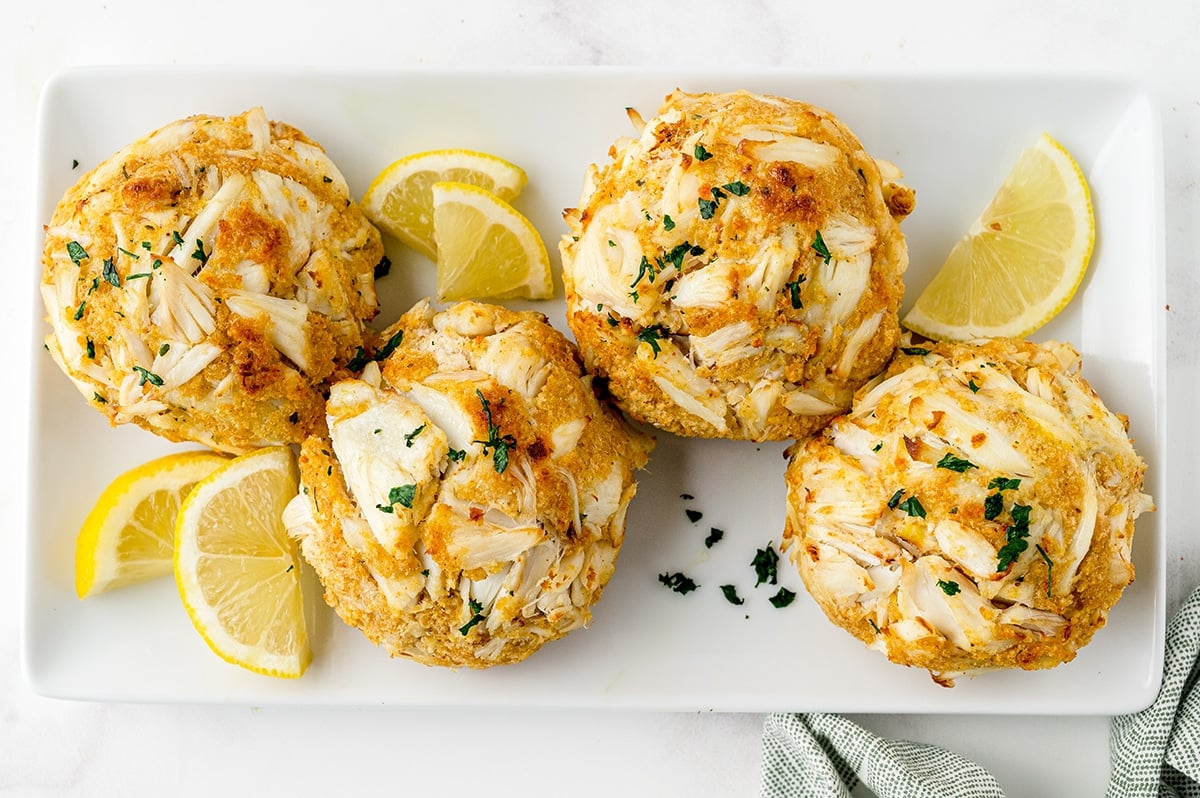 maryland style crab cakes on a serving dish with lemon wedges