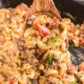 close up of wooden spoon full of hamburger helper skillet