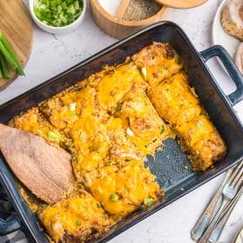 overhead shot of sliced cheesy hash brown casserole in dish