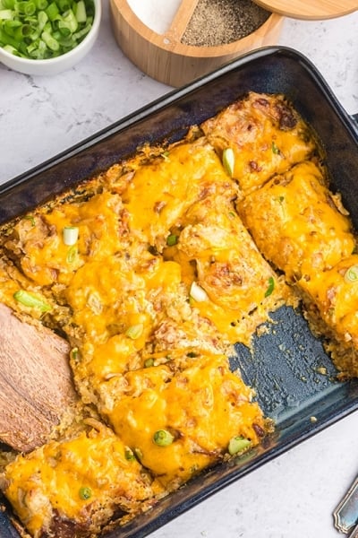 overhead shot of sliced cheesy hash brown casserole in dish