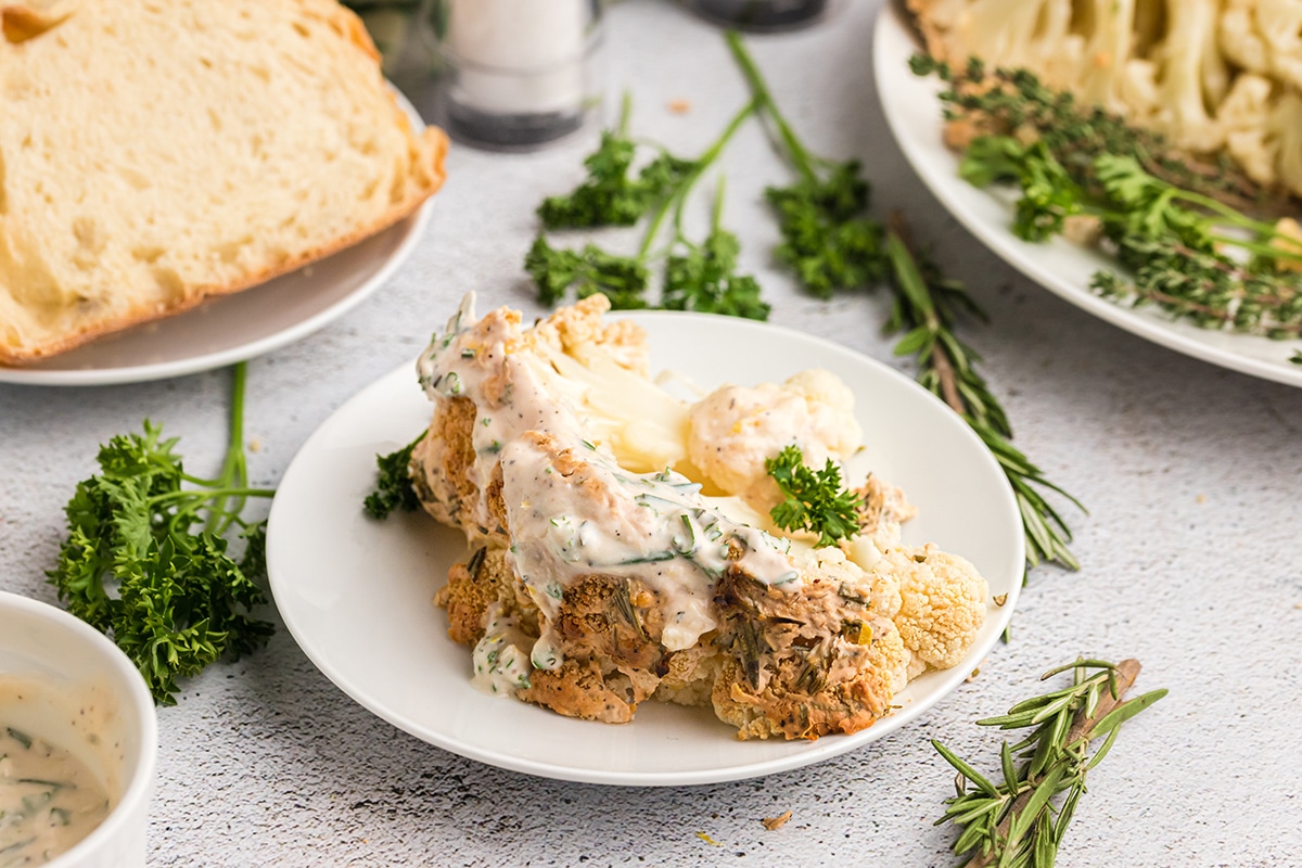 slice of whole cauliflower on plate with sauce