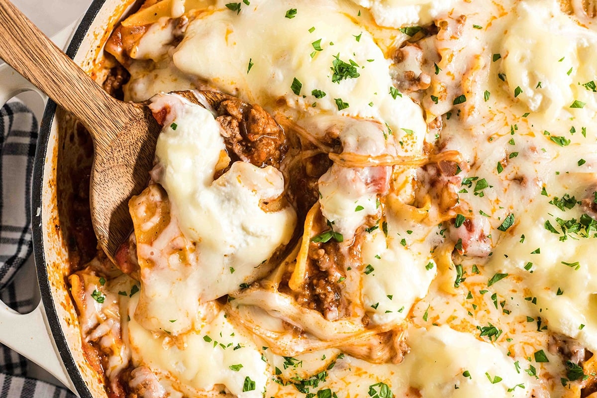 close up of wooden spoon in skillet lasagna