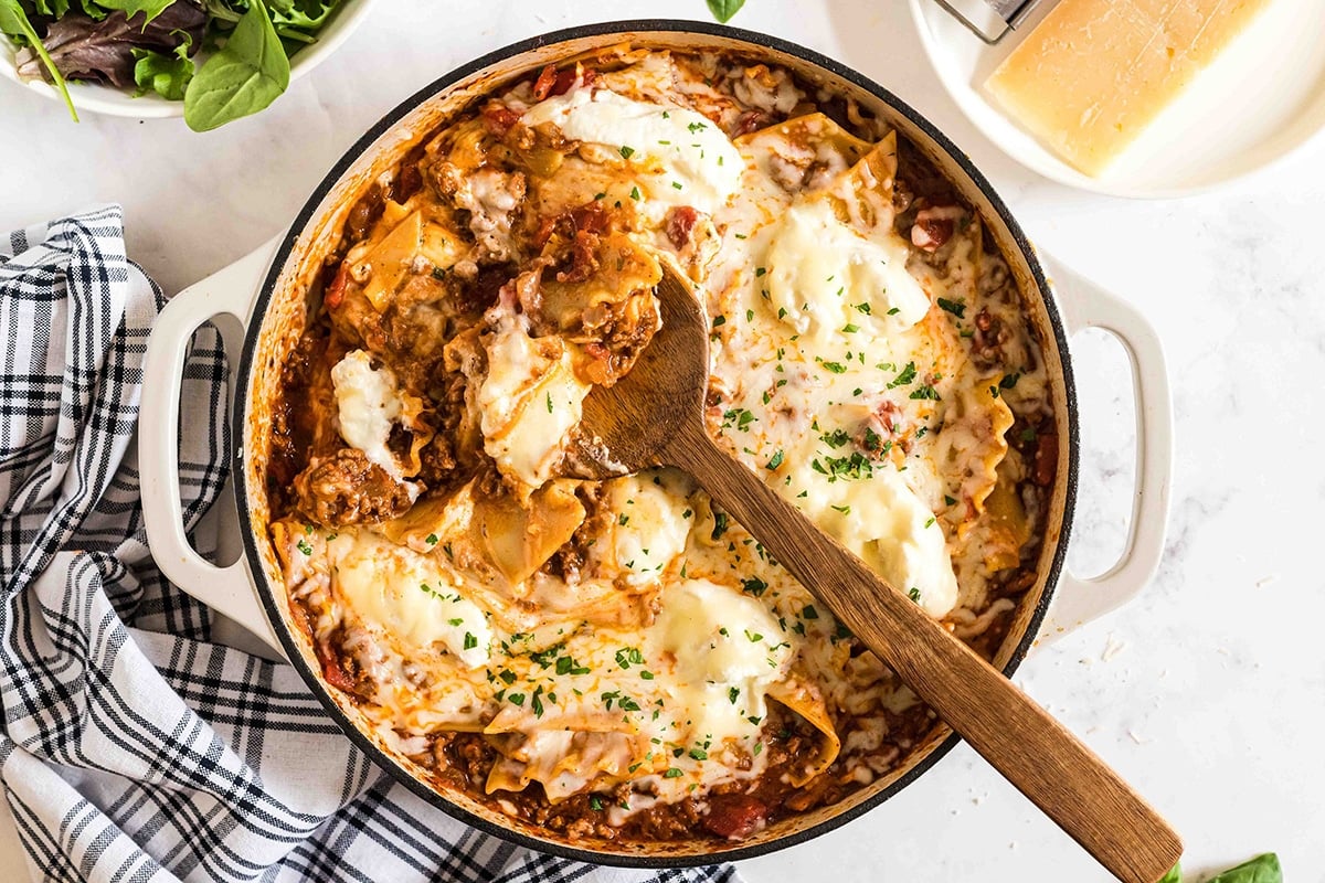 overhead shot of wooden spoon in skillet lasagna