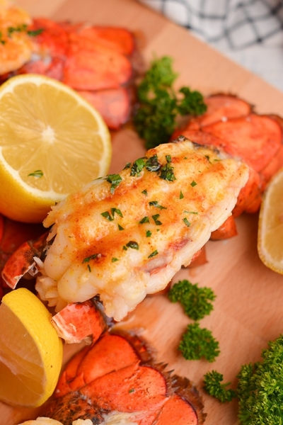 close up of a lobster tail with lemons and parsley