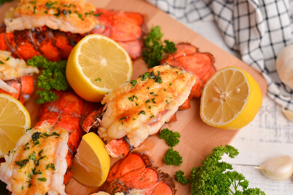 close up of a lobster tail with lemons and parsley