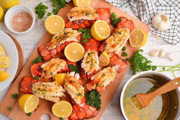 overhead board of lobster tails with fresh lemons and parsley