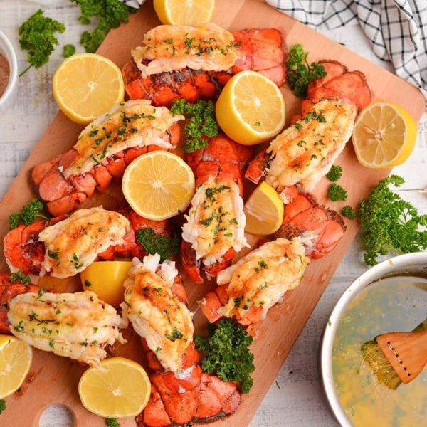 overhead board of lobster tails with fresh lemons and parsley