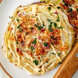 close up of two cabbage steaks on a plate