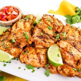 chipotle pollo asado on a white plate with limes