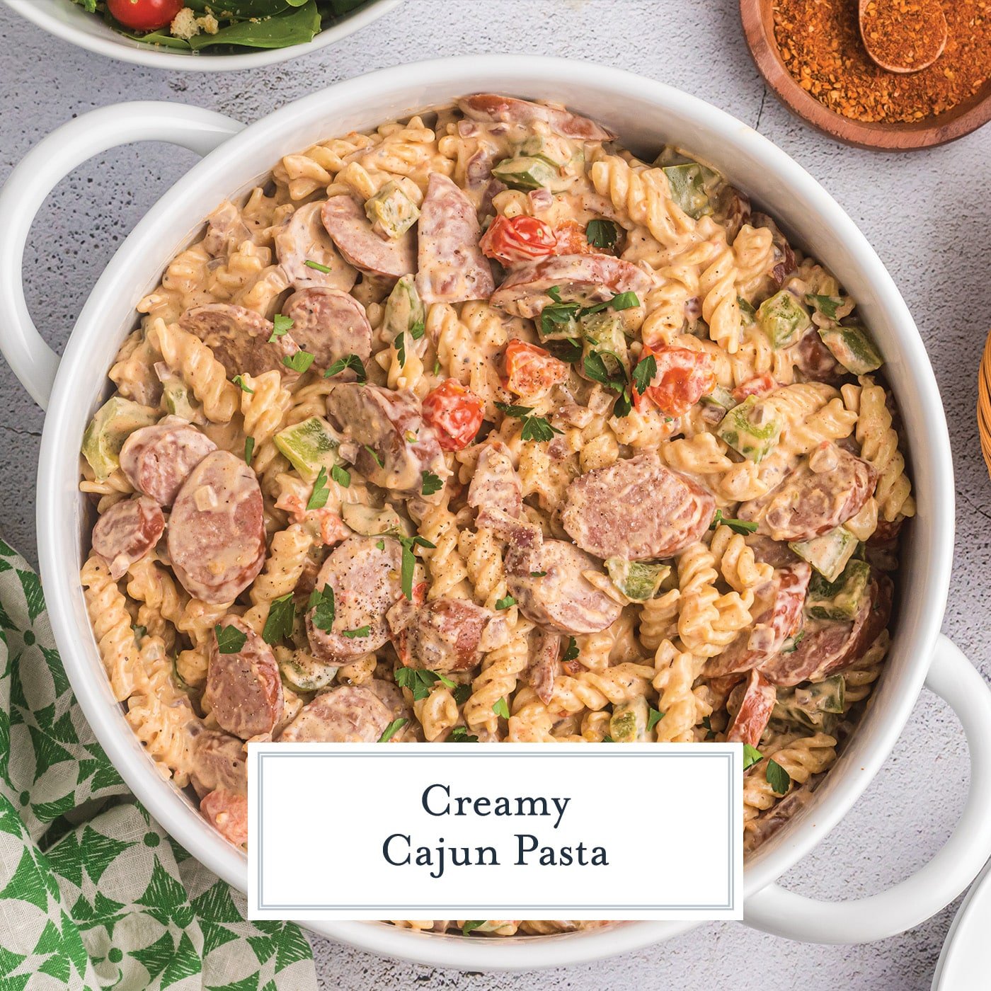 creamy cajun pasta in a white dish with text overlay for facebook