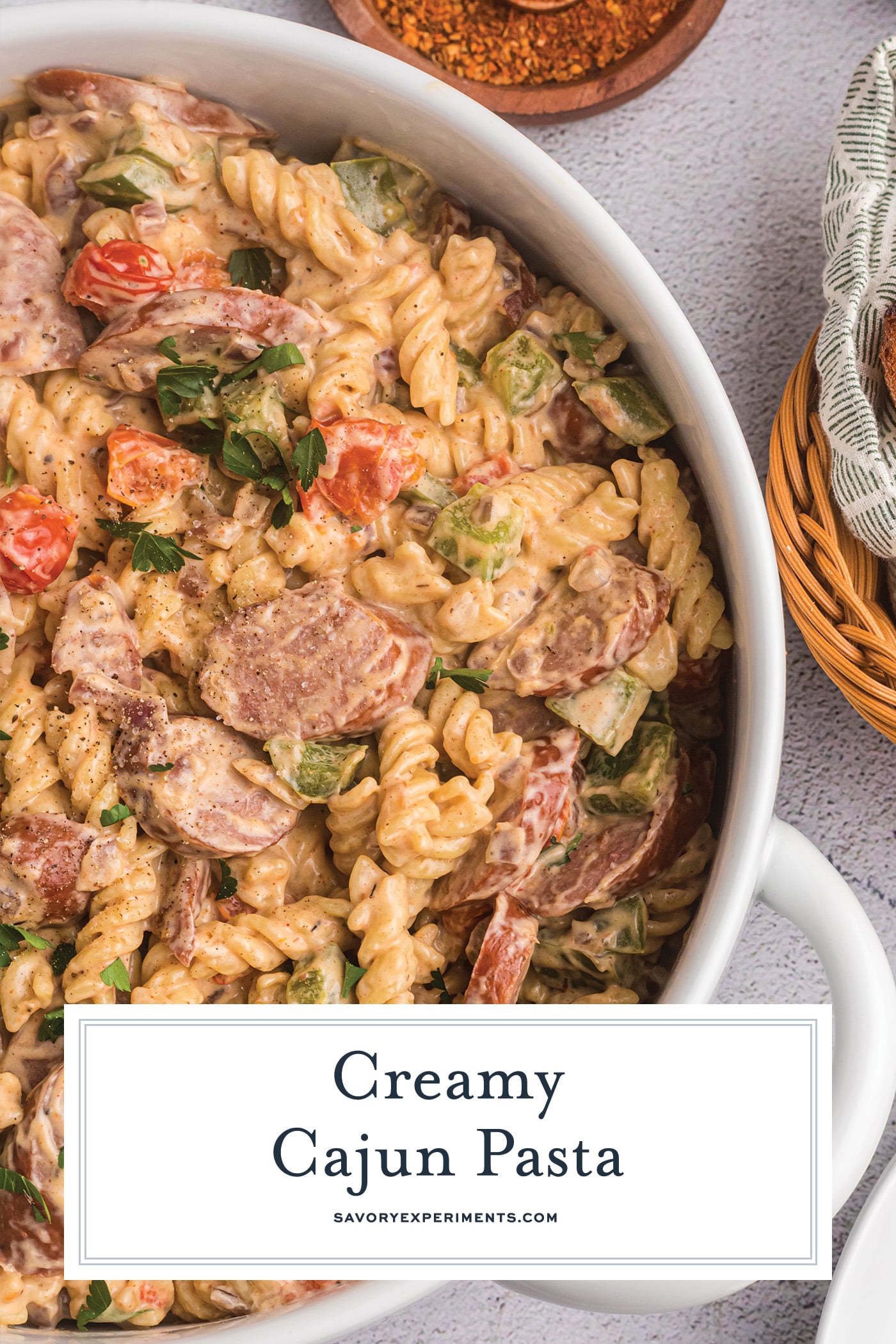 creamy cajun pasta in a white dish with text overlay for pinterest