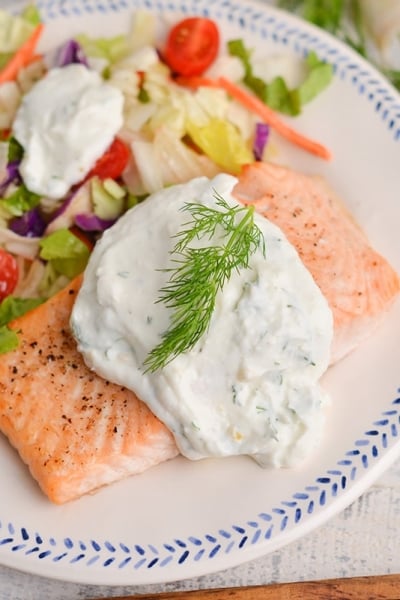 angled shot of creamy dill salmon on a plate with salad