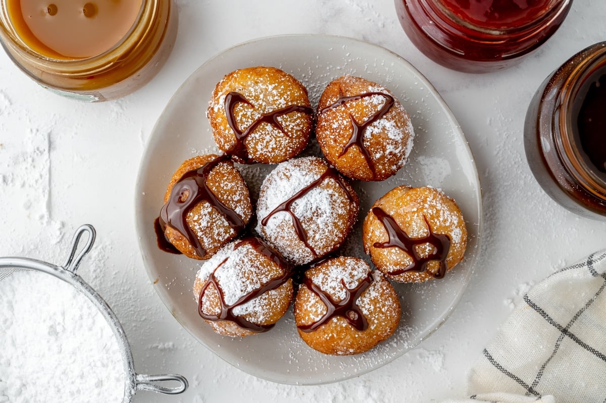 overhead shot of plate zeppoles drizzled with chocolate