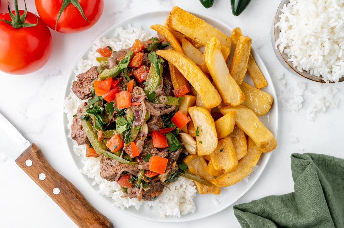 overhead plate of lomo saltado with rice and fries