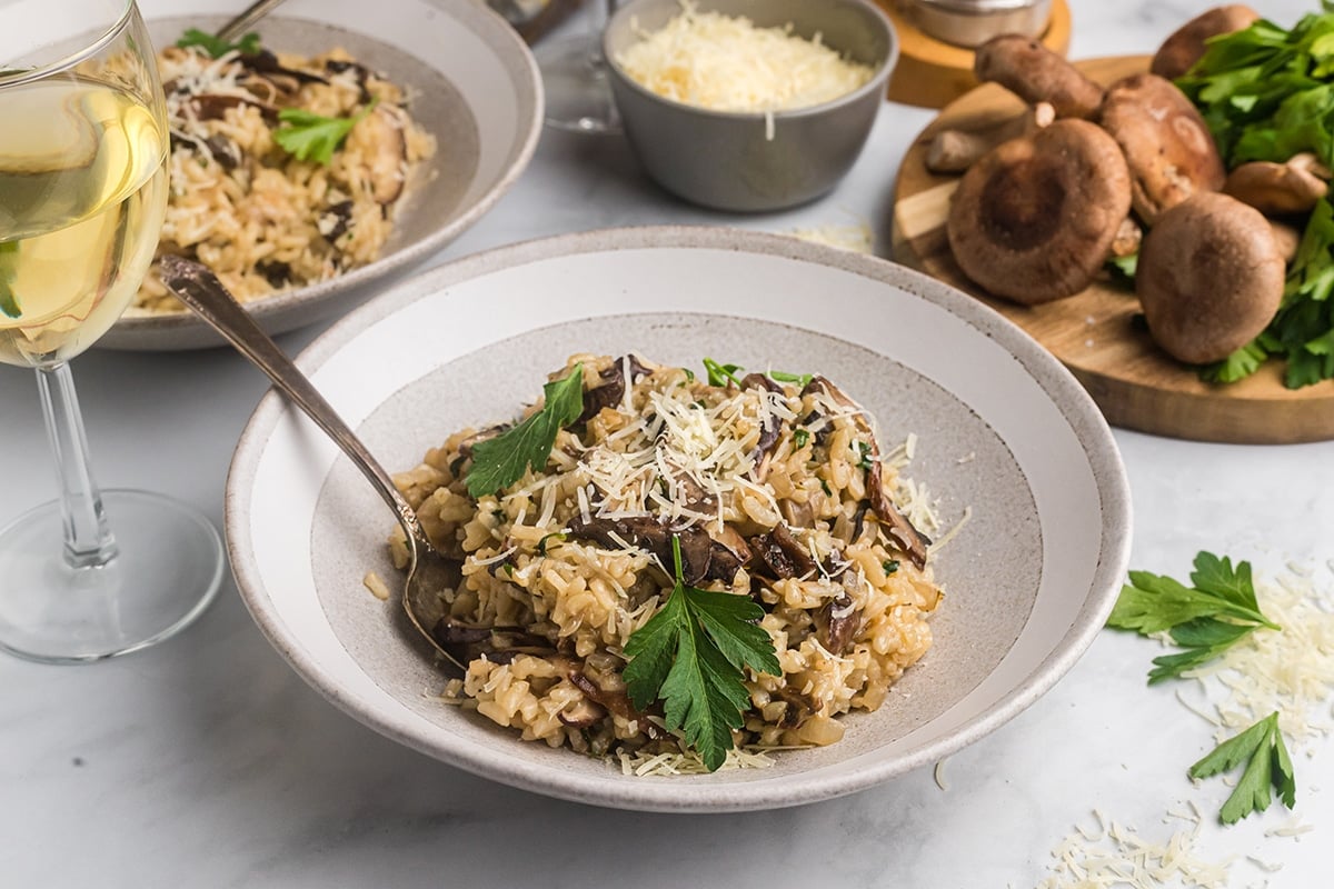 angled shot of mushroom risotto in a bowl with a spoon