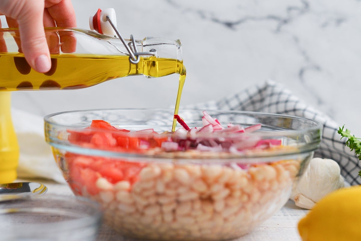 olive oil pouring over bean salad recipe