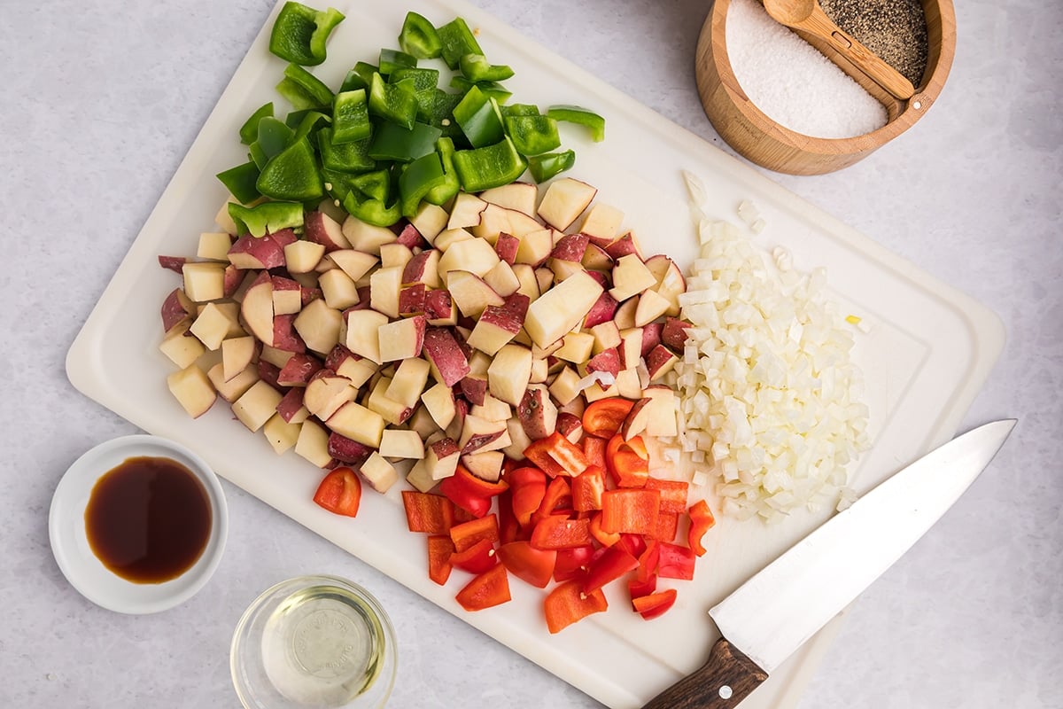 potatoes, onion and peppers cut on cutting board