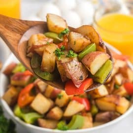 wooden spoon full of potatoes and peppers