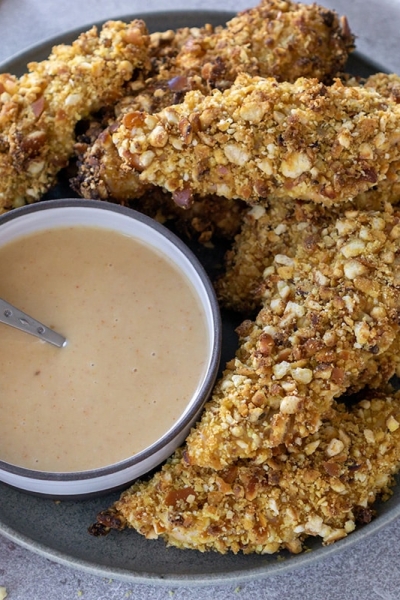 plate of pretzel crusted chicken tenders with sauce