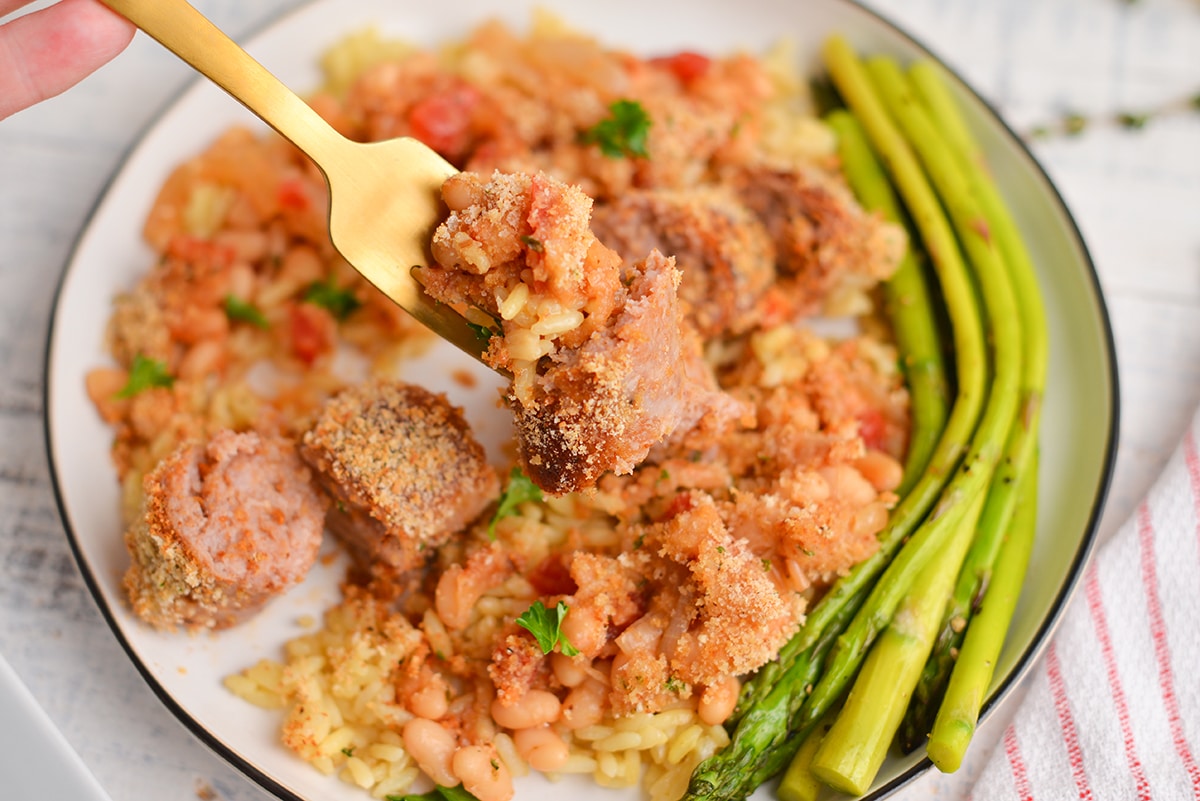 sausage and beans on a gold fork