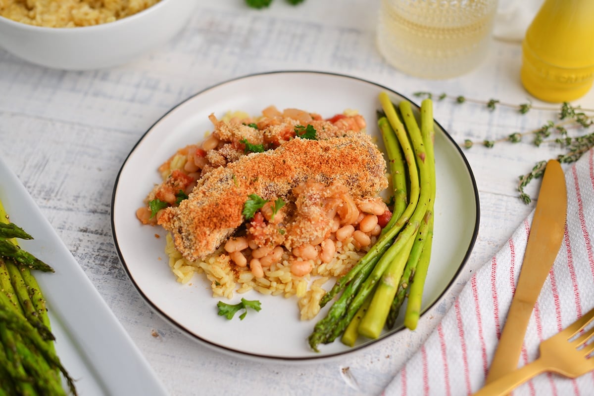 angle of sausage with bread crumbs on a plate with asparagus