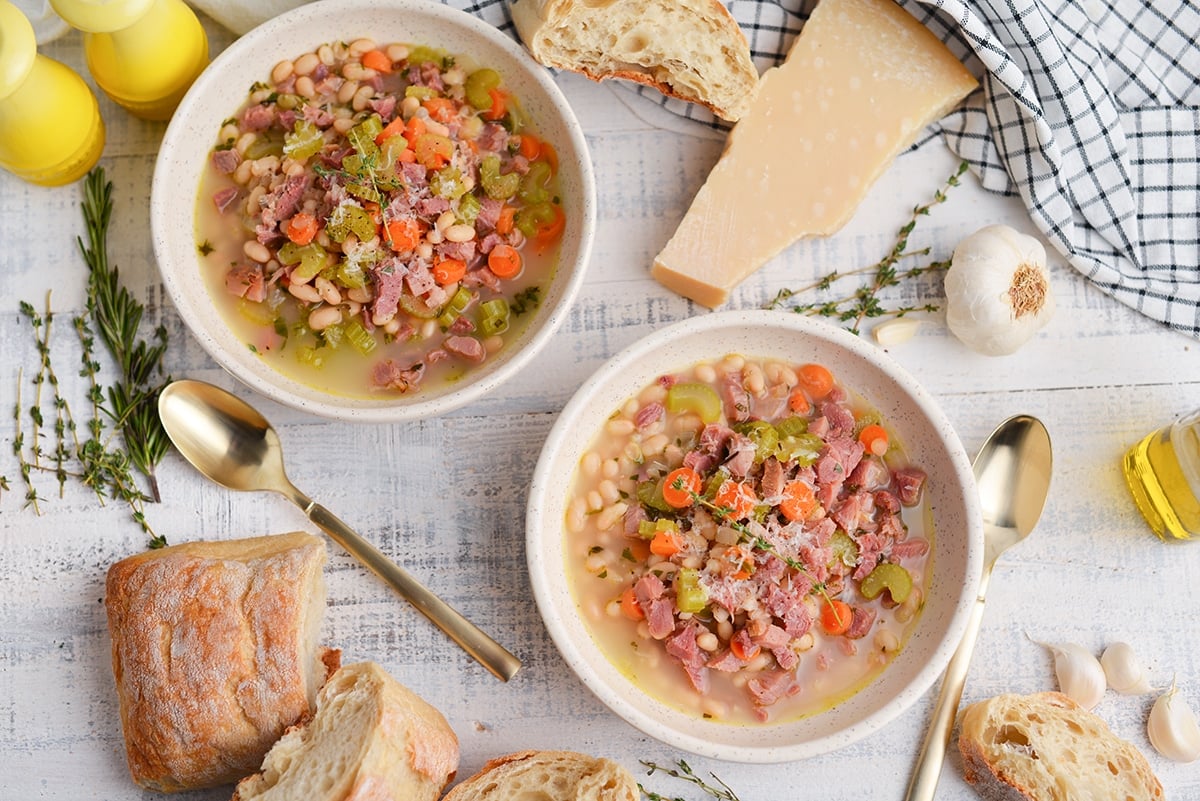 two bowls of white bean soup with parmesan cheese topping