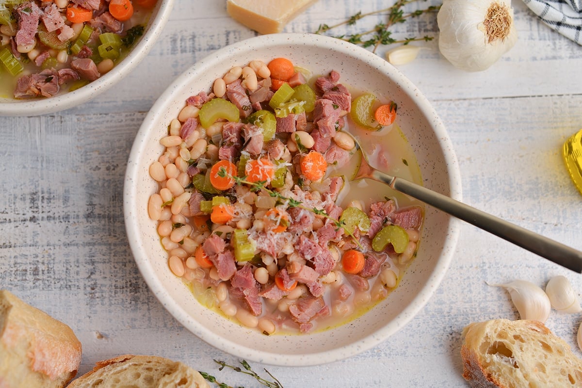 gold spoon in a bowl of bean and ham bone soup