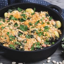 skillet of creamed kale gnocchi with beans