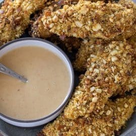 plate of pretzel crusted chicken tenders with sauce