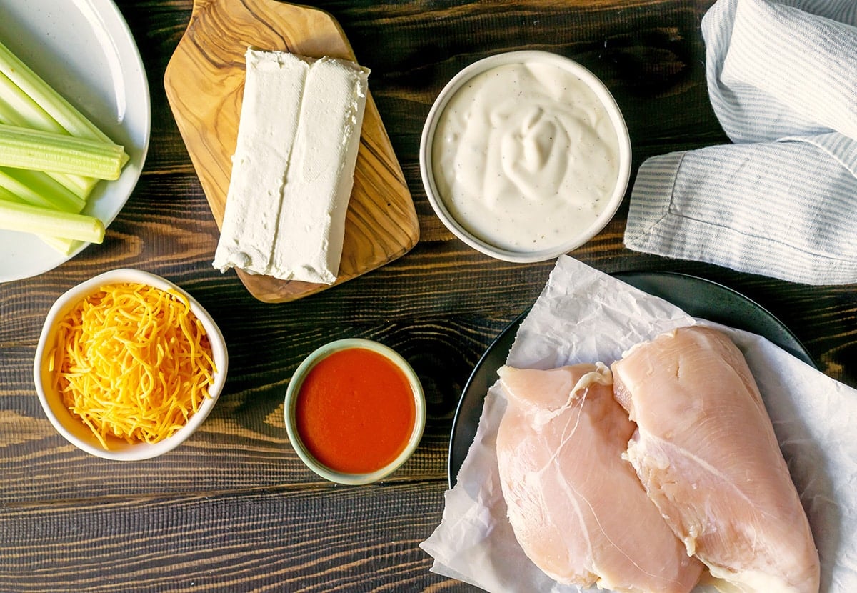 ingredients for buffalo chicken dip: chicken, hot sauce, celery, cream cheese, cheddar and ranch