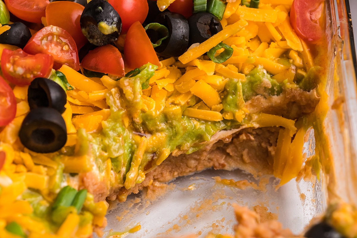 close up of scoop of taco dip taken out of dish