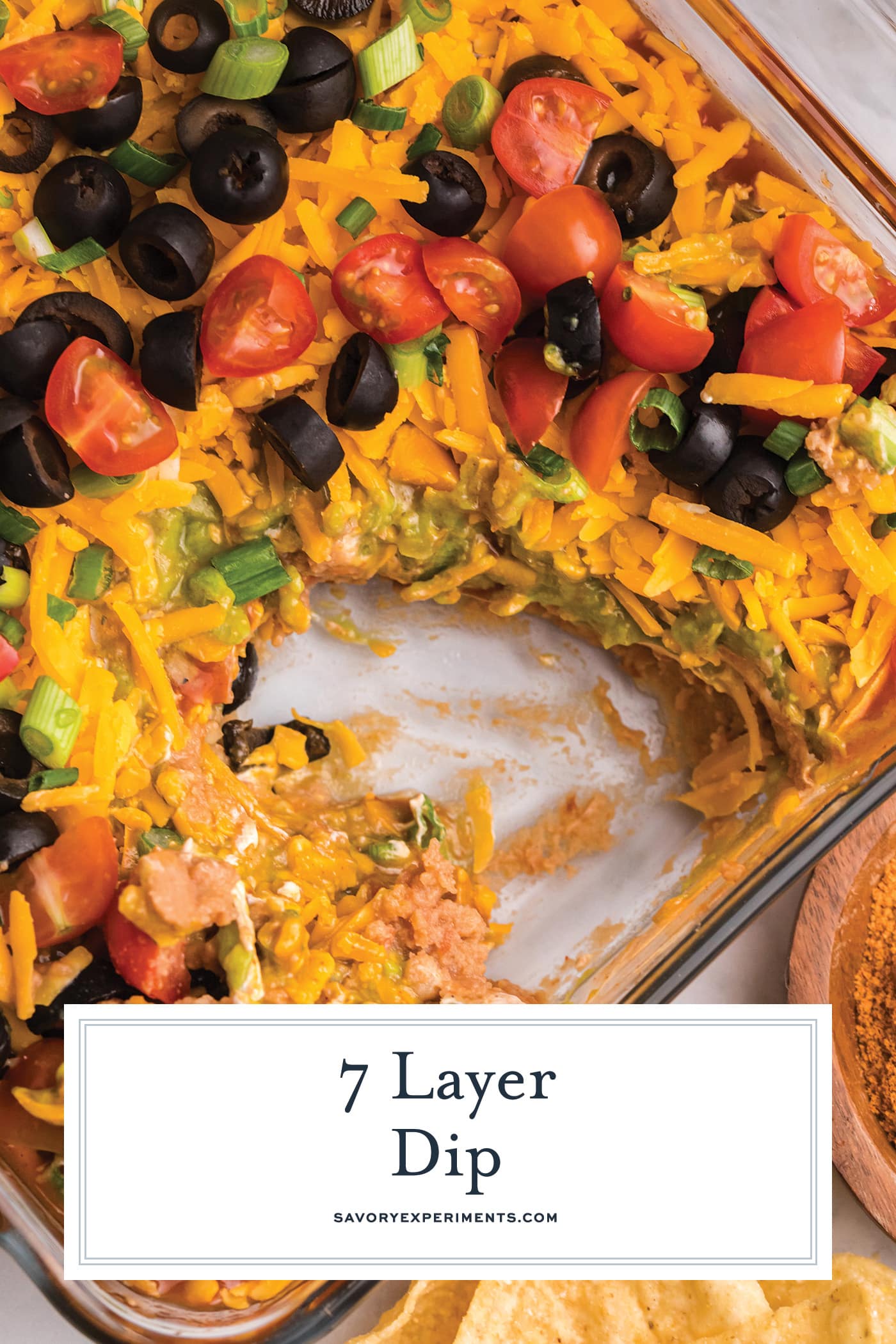 scoop taken out of seven layer dip with text overlay for pinterest