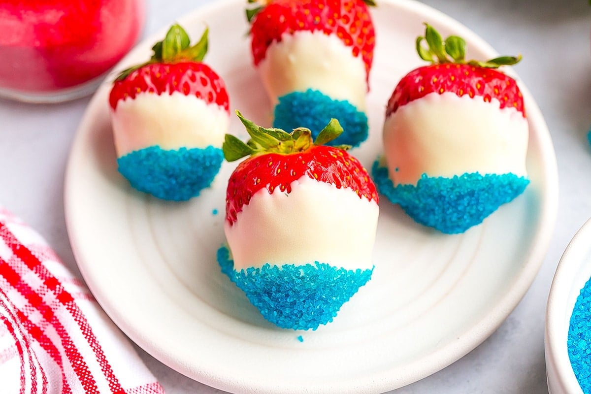 four red white and blue strawberries on a plate