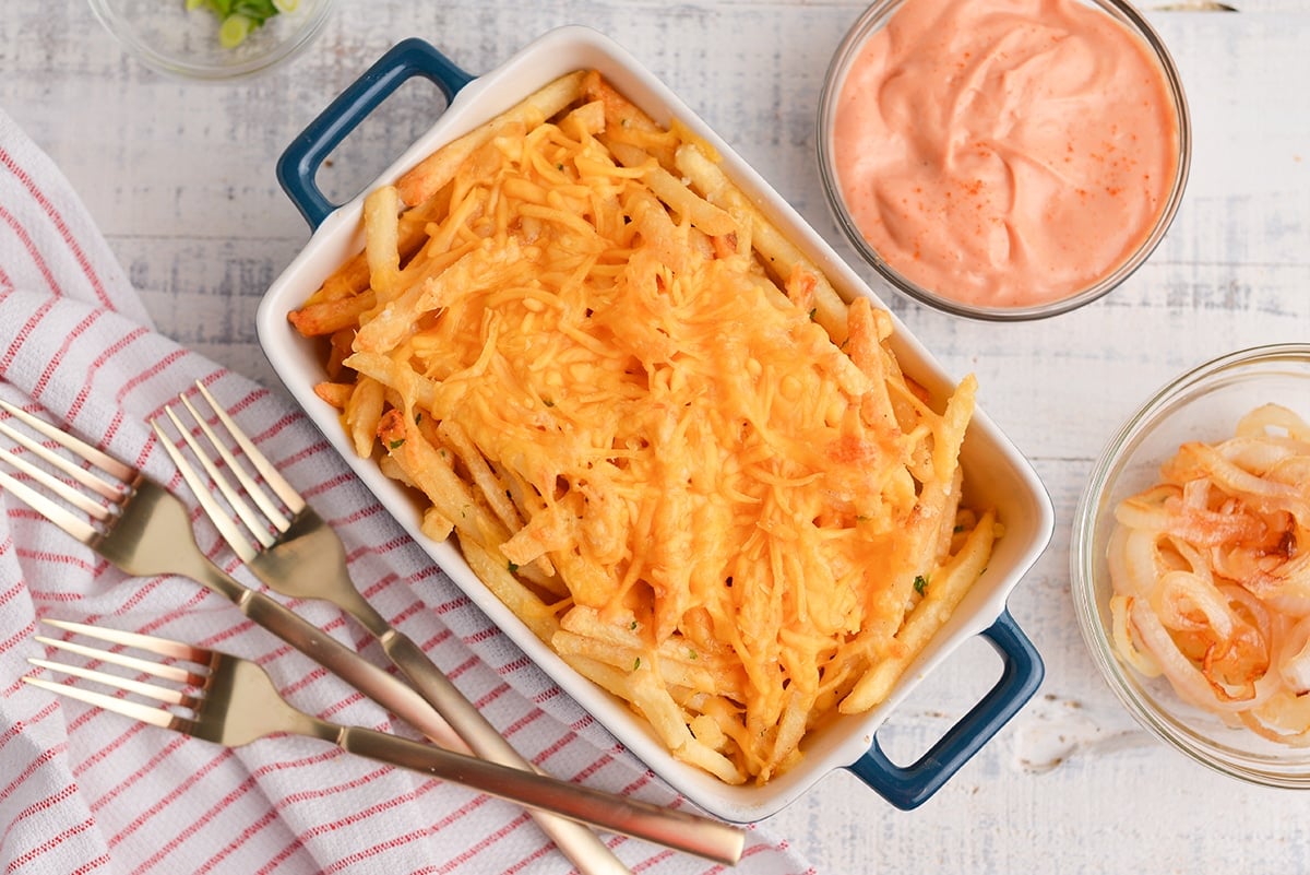 overhead of french fried with melted cheese in a baking dish