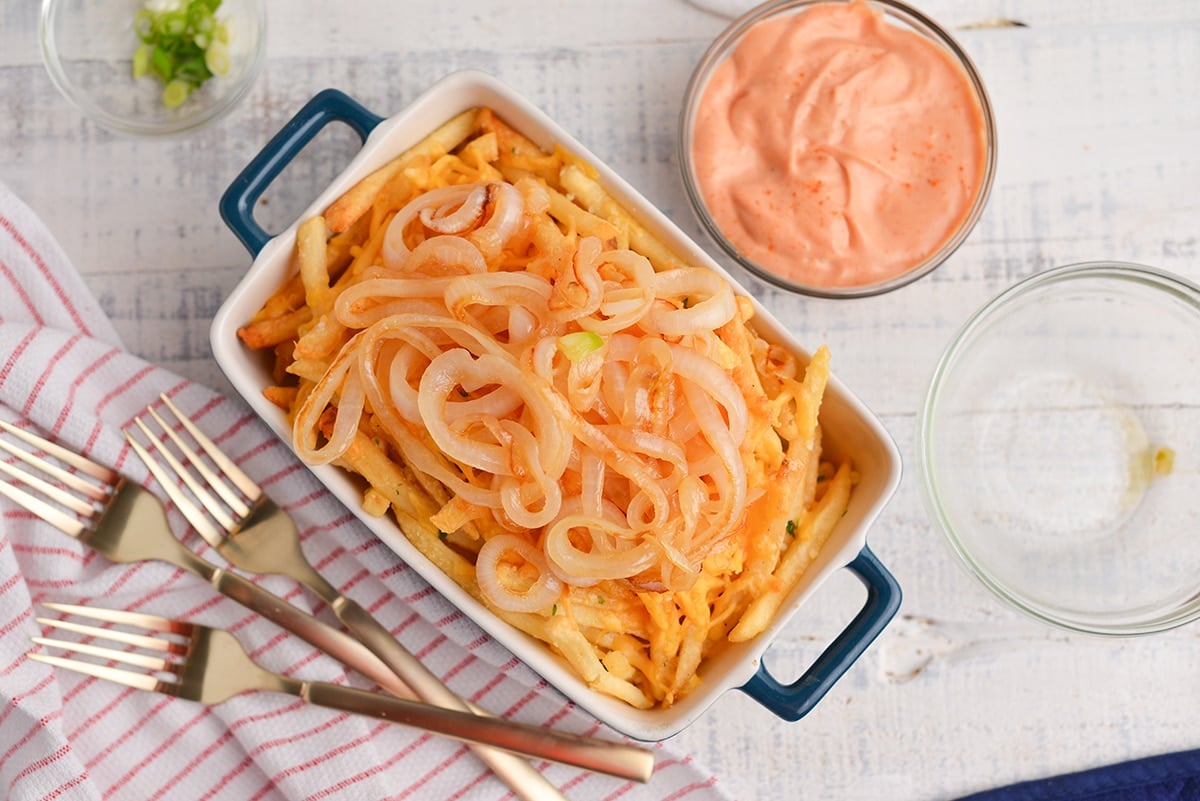 cheesy fries with caramelized onions in a baking dish