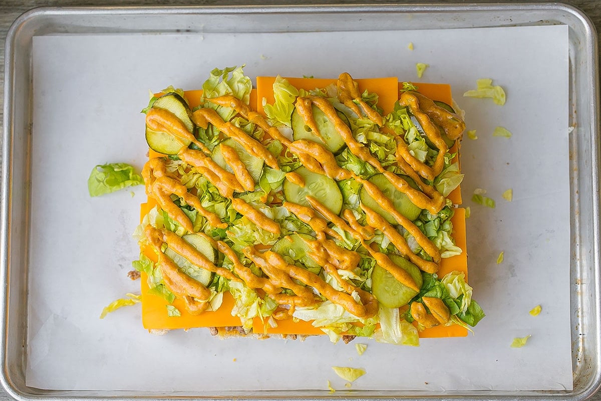 sauce drizzled on top of lettuce and pickles