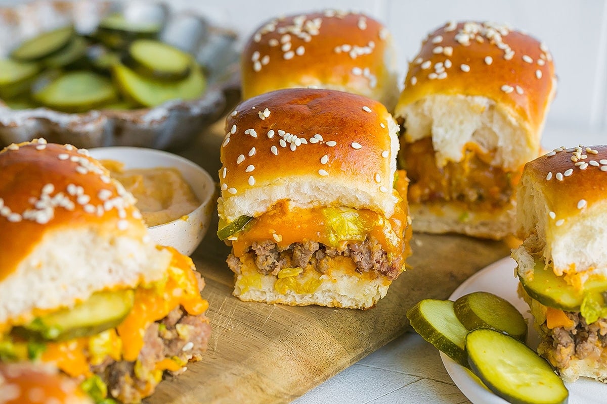 pickles and big mac sliders on a cutting board