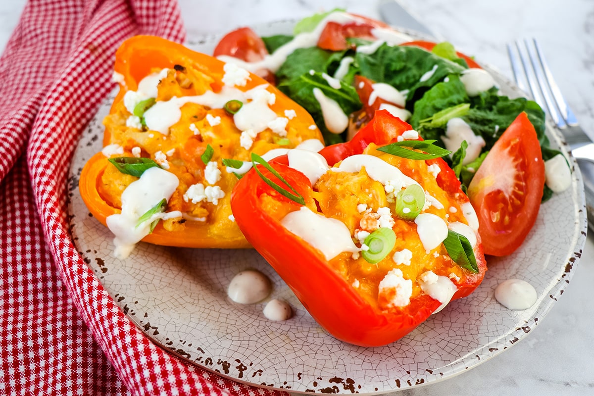 two buffalo chicken peppers on a plate with salad