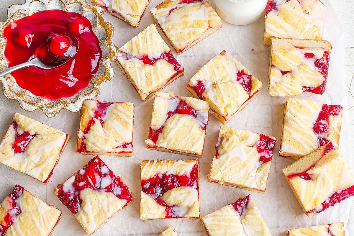 cherry pie bars on parchment with filling