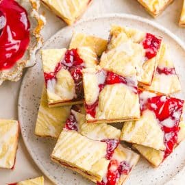 cherry pie bars on a white speckled plate