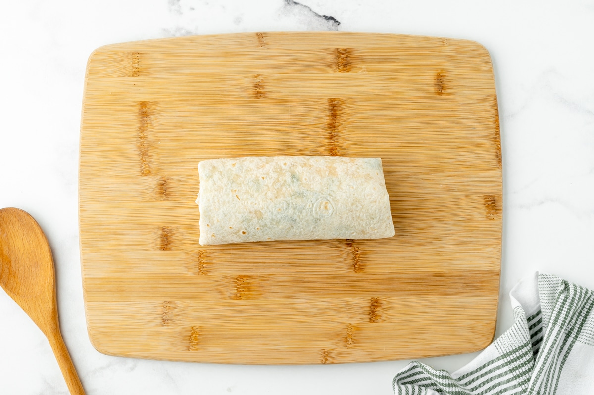 rolled chicken enchilada on a cutting board