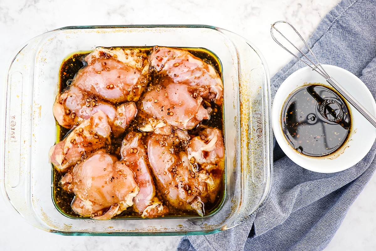 chicken thighs marinating in glass dish