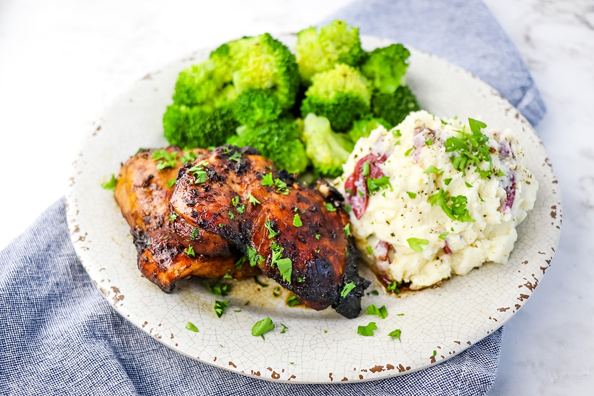 chicken thighs on plate with mashed potatoes and broccoli