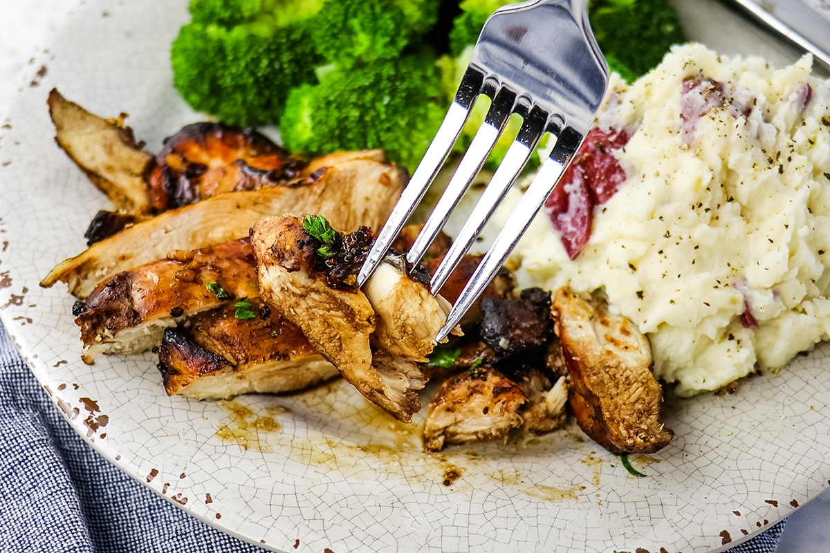 fork taking bite of chicken thighs in air fryer