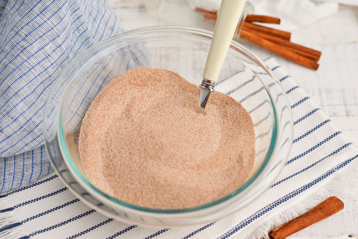 clear glass bowl with cinnamon and sugar mix and a spoon