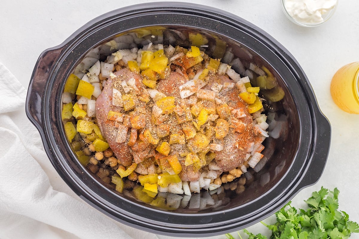 overhead shot of chicken and onions in slow cooker